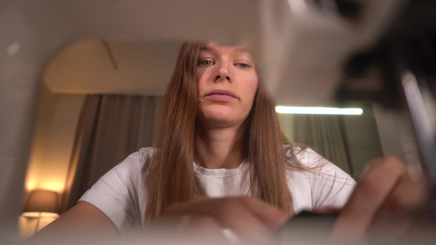  Woman sews on a sewing machine. Woman works at home.