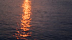 Beautiful defocused abstract golden blurry sea water background. Aerial view at soft waves of sea with soft sunset sun light reflection on peaceful surface.