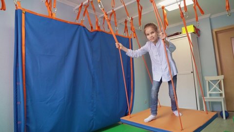 a girl on Platform suspended projectile for classes on method of sensory integration and correctional and developmental technologies. games and educational activities. therapeutic exercise.
