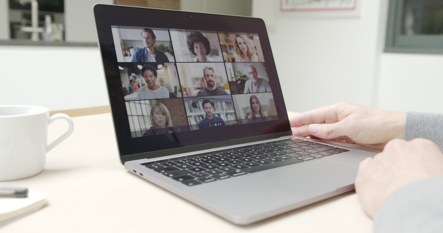 Person Using Video Conferencing technology in kitchen for video call with colleagues at home and in offices
