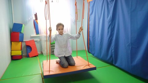 little girl on Platform suspended projectile for classes on method of sensory integration and correctional and developmental technologies. games and educational activities. therapeutic exercise.