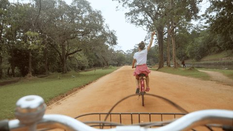 POV point of view of couple on bicycle enjoying sightseeing in Sri Lanka, man personal perspective cycling thing girlfriend in the jungle, couple having fun travel vacations 