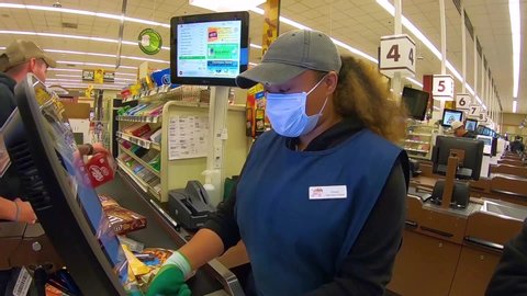 CIRCA 2020 - grocery store supermarket checkout workers are essential during the coronavirus Covid-19 epidemic outbreak.