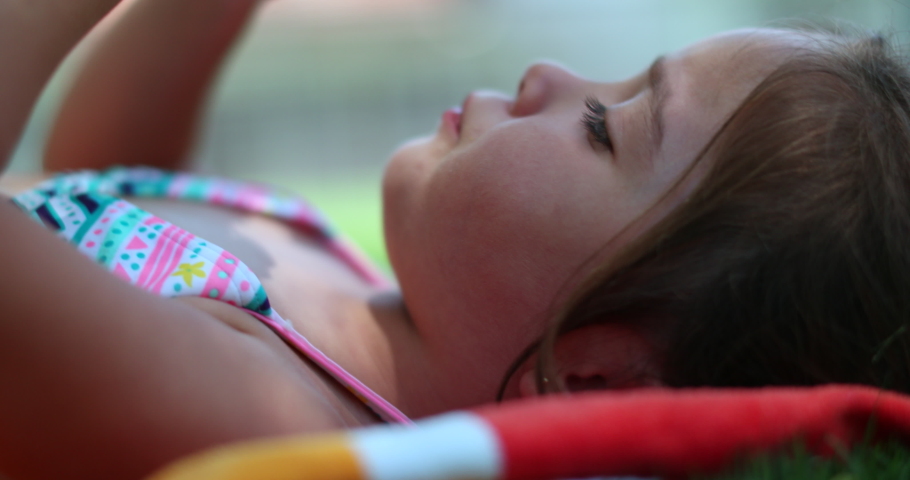 Playful child girl eating vegetable corn outside in picnic