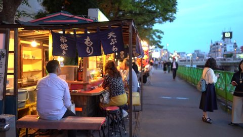 Fukuoka, Japan - July 12, 2019: Local Japanese visitors are seen having meal at famous food stalls or "yatai" in Nakasu, Fukuoka.
