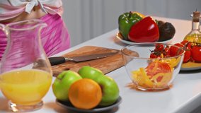 Cropped view of woman cooking healthy salad on table in kitchen