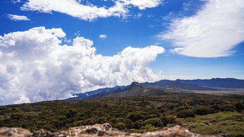 Time lapse view of Kilimanjaro National park at Mount Kilimanjaro. Beautiful landscape with clouds floating over the volcanic area.