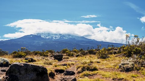 Time lapse view of Kilimanjaro National park at Mount Kilimanjaro. Beautiful landscape with clouds floating over the volcanic area.