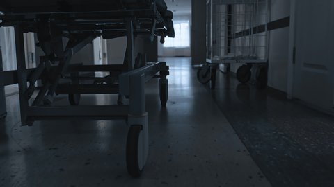 medical gurney or stretcher goes quickly through emergency department or intensive care unit, critically ill patient sent to reanimation or operating room in crowded hospital, pandemic