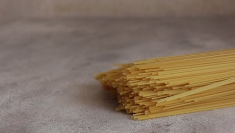 Raw pasta before cooking on a light background. Presentation and rolling out of pasta. Concept of cooking pasta in the kitchen. Copy space. The pasta is the best