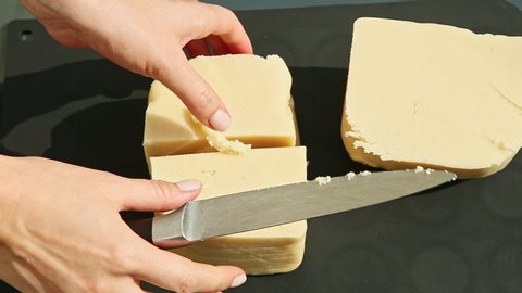 top view woman hand slice by knife big cubes of white homemade marzipan mass served on black table surface