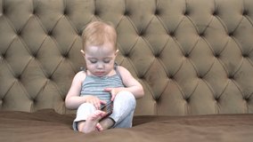 cute little girl using digital devices while lying on bed