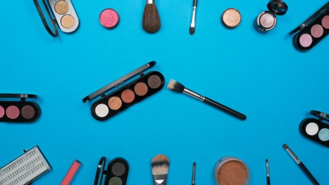 Cosmetics set for women on blue paper background,top view stop motion animation timelapse