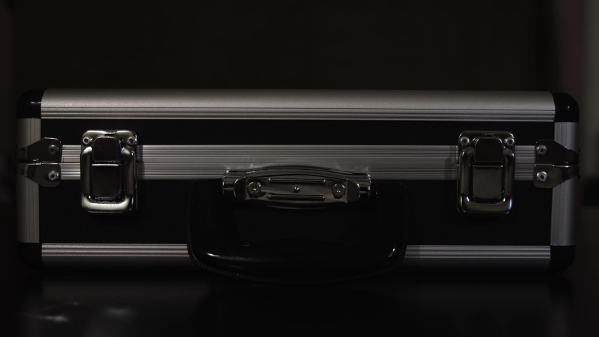 Close up of female hands opening silver metal suitcase with locking system. Concept. Opening aluminum carrying case to find shining mysterious object inside. Royalty-Free Stock Footage #1050075823