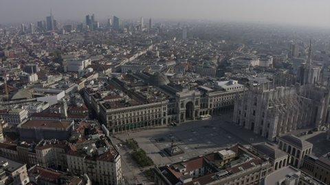 Daily life in Milan, Italy during COVID-19 pandemic. Milano, Italian city and coronavirus outbreak. Aerial view of Piazza Duomo with cathedral and square seen from drone flying in sky