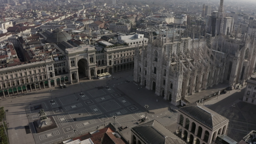 Daily life in Milan, Italy during COVID-19 pandemic. Milano, Italian city and coronavirus outbreak. Aerial view of Piazza Duomo. Historic monument and religious building seen from drone flying in sky | Shutterstock HD Video #1050084151