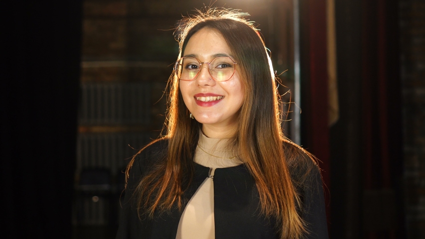 Smiling girl in glasses. Beautiful backlight