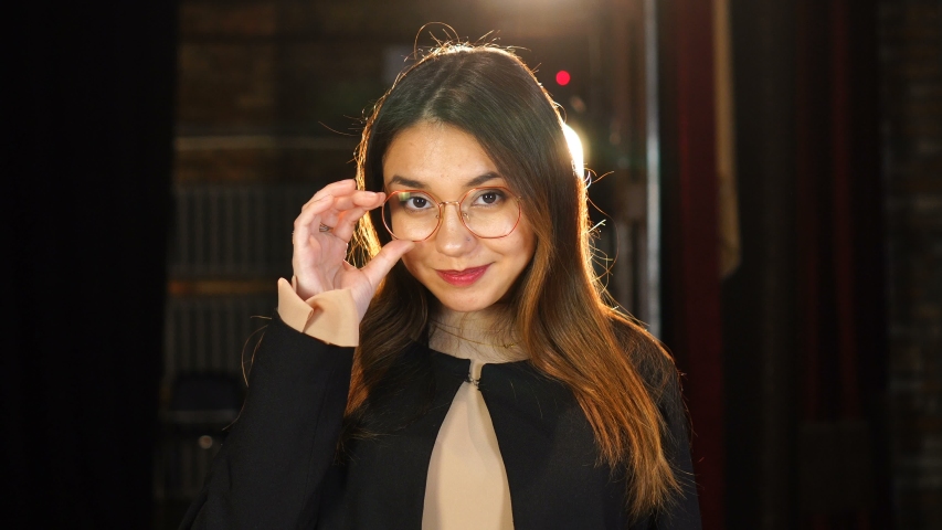 Portrait of girl in glasses. Young woman looking at camera. Beautiful backlight