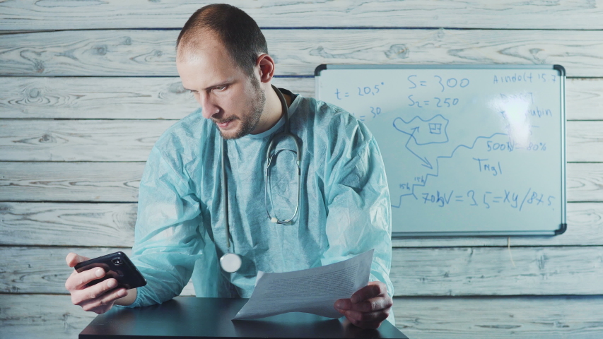 a doctor in uniform with a phonendoscope talks to a patient in a video chat application. coronavirus, covid-19 concept Royalty-Free Stock Footage #1050090877