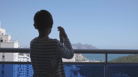 Kid applauding medical staff from their balcony. People in Spain clapping on balconies and windows in support of health workers during the Coronavirus pandemic