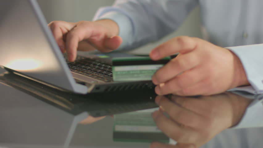 Businessman inserting credit card number, online banking service