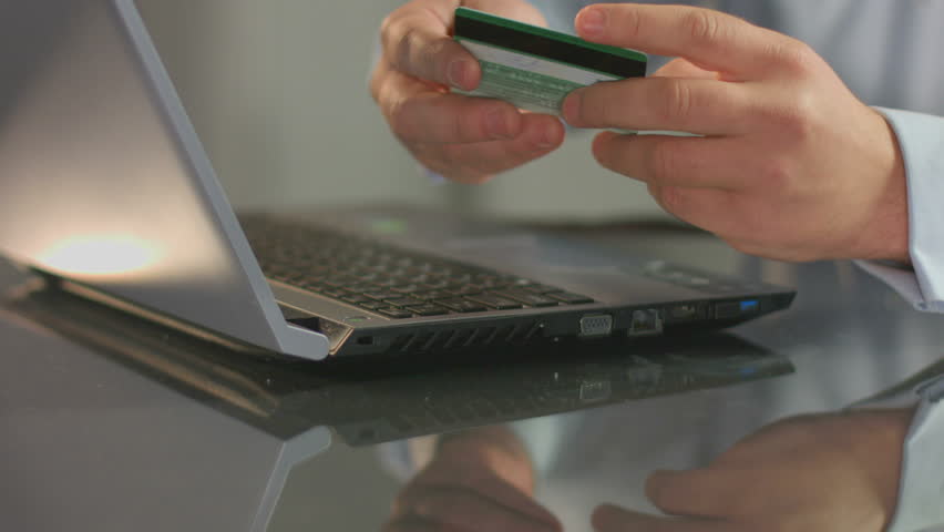 Man paying bill, shopping online, inserting credit card number