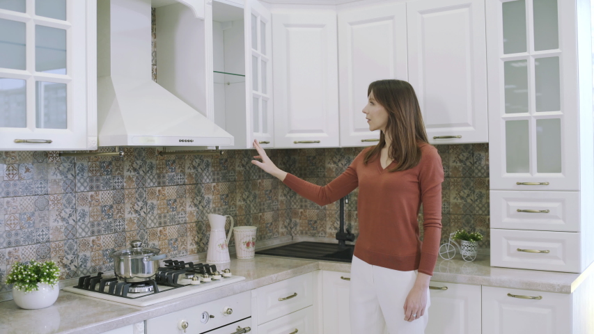 Pretty girl choosing furniture for home kitchen in shopping center. Young woman examining samples of kitchen sets in furniture store. Home remodeling and renovation concept