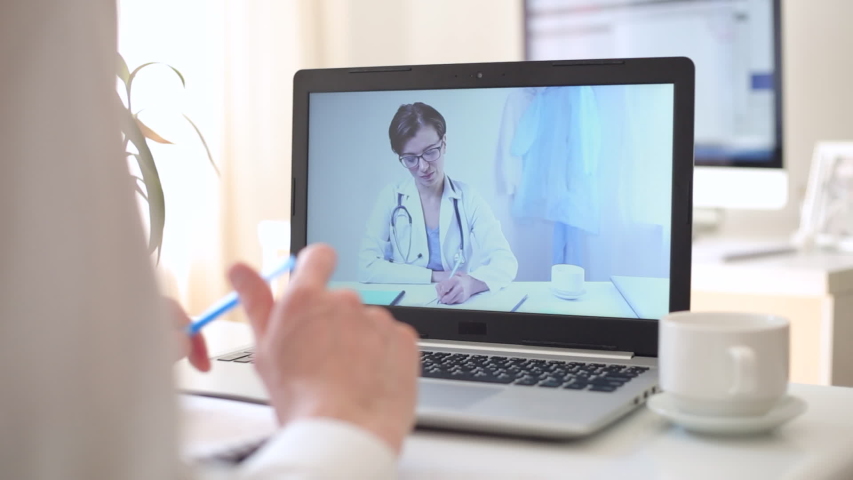 A female doctor consults a patient through an online video chat conference. | Shutterstock HD Video #1050124255