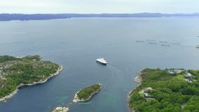Small ferry sailing away from the pier in a fjord in Norway. The area is in a remote area of Norway, with beautiful landscape and nature around. Drone stock footage video by DroneRune