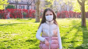 A little girl of European appearance takes off her protective medical mask and has fun, she is happy at the end of the disease. Emotionally. Coronavirus epidemic, Children, victory on the virus