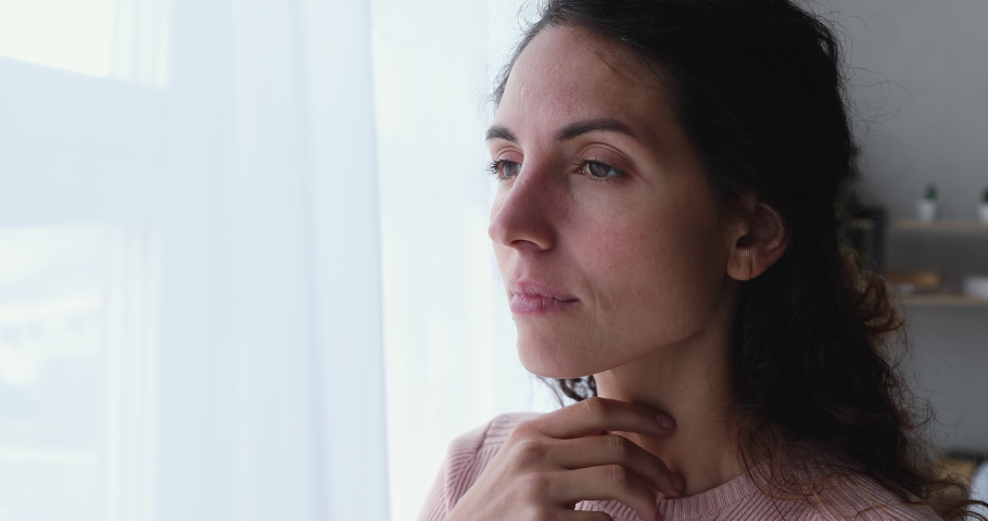 Pensive worried young adult woman looking outside through window. Thoughtful serious lonely lady feeling sad or melancholic, reflecting alone, thinking or loneliness, solitude concept. Close up view Royalty-Free Stock Footage #1050127729