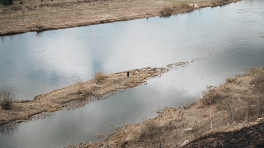 A fisherman walks on an island in the river. The spring fishing. Recreation and Hobbies.
