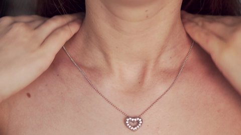 Girl wearing pendant, close up, unrecognizable