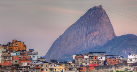 Timelapse of the evening sun setting on favela houses in Rio de Janeiro Brazil with the Sugarload mountain in the background