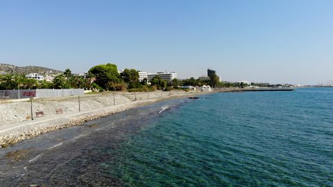 Stationary Aerial Shot of Crashing Waves on the Beach Front in Limassol, Cyprus with Pedestrian Path, Hotels, Waves, and More in View