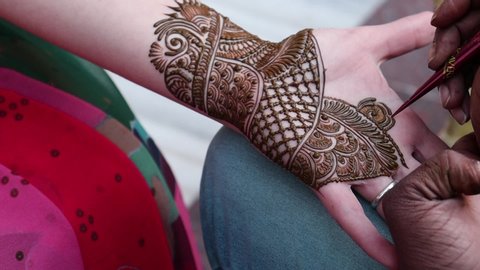 Traditional Indian temporary tattoo realized with henna paste during the Mehndi ceremony during the preparation for a Hindu wedding. Indian marriage traditions. Agra, Uttar Pradesh, India.