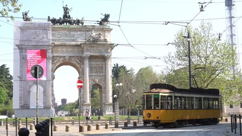 Europe, Italy, Milan - april 2020 - Old vintage yellow street car railway tram without advertising in Arch of Peace ( Arco della pace ) during n-cov19 Coronavirus outbreak - empty street and square  