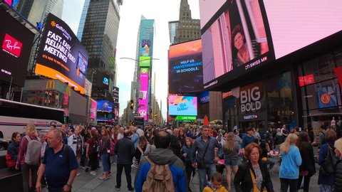 New York, NY, USA. October 18, 2019. Crowded Time Square and billboards on buildings facades at late afternoon or early evening. Thousands of people walking in Time Square and Broadway