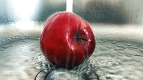 Red apple being washed in the sink for hygiene.Natural healthy food ingredients for good nutrition.Wash and sanitize fruits for health.Footage of fruit theral treatment in kitchen at home