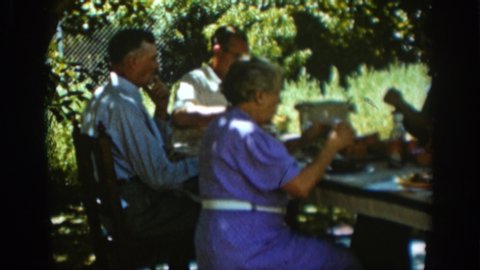 AUBURN CALIFORNIA-1939: A Rarer Family Gathers Outside On A Hot And Humid Summer Day Under The Shade Where They Share Food