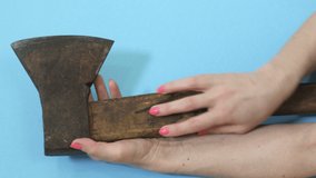 Woman touching old ax on blue background