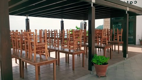 Empty outdoor panorama cafe in south country. Closed public places. Rows of chairs upside down on tables, global crisis of touristics industry due to coronavirus Covid-19 epidemic. Video de stock