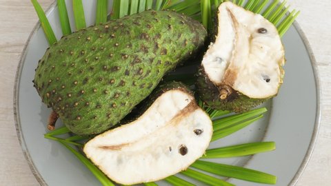 Soursop graviola, exotic, tropical fruit Guanabana on plate, Rotate. Food background