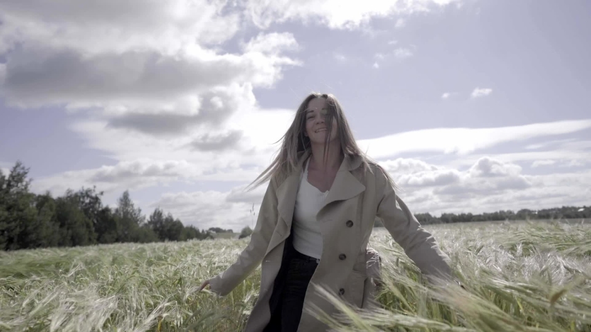 young beautiful girl dancing in the green morning field,
spikelets of wheat