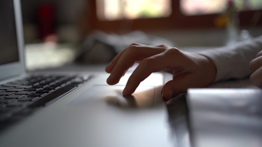 Hand detail of boy using laptop trackpad at home. Royalty-Free Stock Footage #1050204781