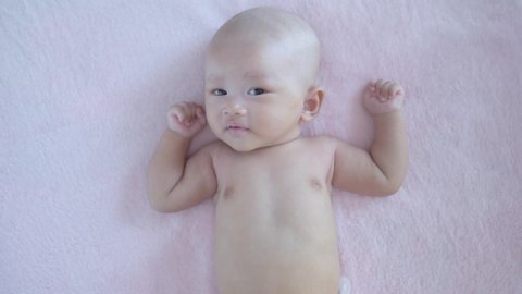 Asian cute newborn baby is hiccupping and happy time on bed, Baby healthy concept.