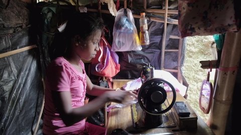 
Teknaf, Bangladesh - November 2018:  A Rohingya girl is using a sewing machine to make clothes in the Teknaf refugee camp. 