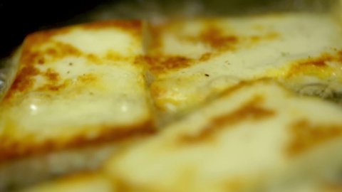 Closeup shot of deep frying cottage cheese in oil in pan.
