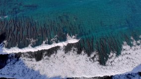 Ocean reef off the coast of Bali video from a drone. Huge ocean waves roll on the shore and break. Bird's-eye view of the reef