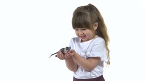 Cute child is holding large decorative gray rodent with a wool tail at white background. Slow motion